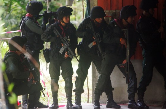 Thai police stand guard after a suspected insurgent attack at a military base in southern Thailand on Wednesday. Scores of heavily armed gunmen stormed the base in a major assault that left 16 militants dead.