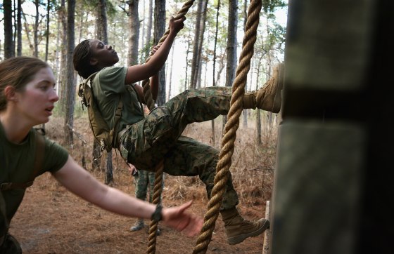 Pfc. Michaela Walker and Pfc. Britney James climb an obstacle on the Endurance Course.