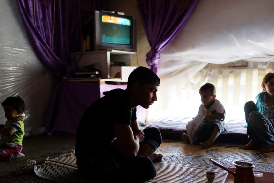 Members of a Syrian family from the city of Homs watch television in their tent inside of a camp for Syrians who have fled the fighting in their country in Baalbek, Lebanon, Friday. Lebanon is the only neighboring country that has not imposed some kind of restrictions on the flow of refugees from Syria, Human Rights Watch said.