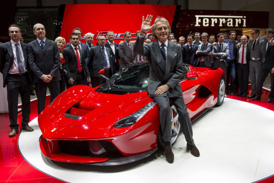 Ferrari President Luca Cordero di Montezemolo (C) waves to media after the World premiere presentation of the new La Ferrari hybrid model car at the I...