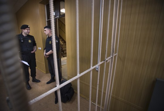Officials stand near a cage in a courtroom in Moscow, Russia, on Thursday. Lawyer Sergei Magnitsky, who died in 2009, was found guilty of tax evasion by a Russian court.