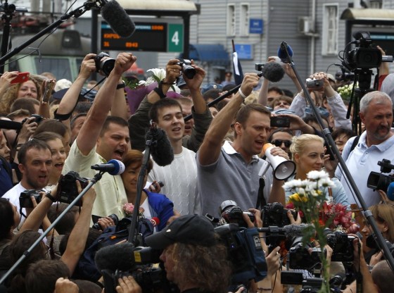 Russian protest leader Alexei Navalny and his co-defendant Pyotr Ofitserov surrounded by supporters and journalists, gesture after arriving from Kirov at a railway station in Moscow, July 20, 2013.
