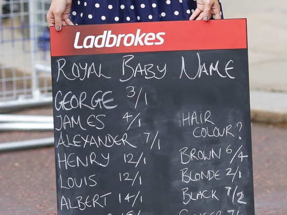 A woman holds a Ladbrokes board listing possible baby names to bet on.