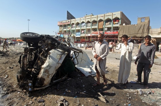 Iraqis inspect the site of a car bomb explosion in the impoverished district of Sadr City in Baghdad. It was one of just a dozen deadly explosions in Iraq Monday.