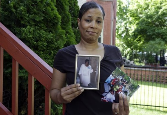 Breast cancer survivor Alicia Cook holds photos of family members who have also been afflicted by breast cancer, outside her home in Chicago.