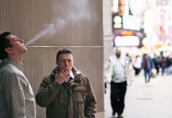 Smokers stand outside of an office building in New York City in 2009. A new study calculates that smokers cost their employers $6,000 more a year than nonsmokers.