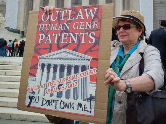 A woman holds a banner demanding a ban over human genes patents during a protest outside the Supreme Court in Washington on April 15.