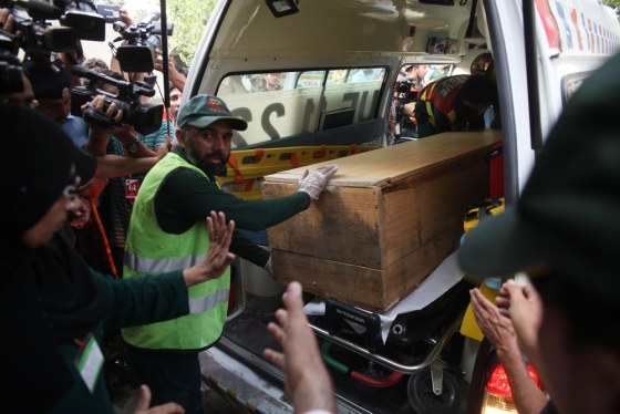 Pakistani rescuers move a coffin of a foreign tourist from an ambulance to a hospital in Islamabad on June 23.