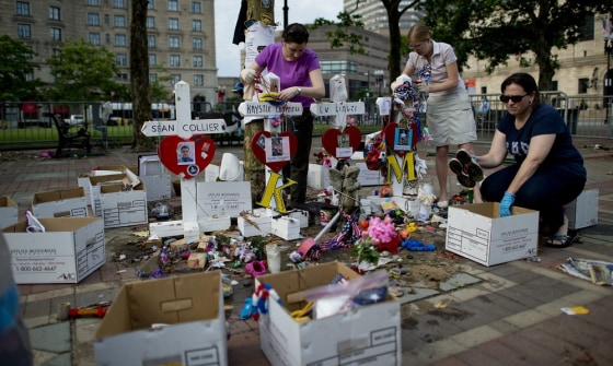 City employees and volunteers remove the remaining items from the Boston Marathon memorial site at Copley Square in Boston on Tuesday.