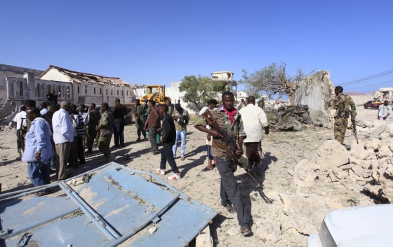 Somali government soldiers inspect the scene of an explosion at a restaurant on Mogadishu's beachfront Friday.