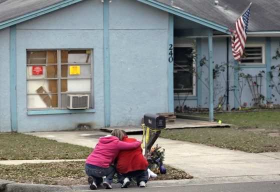 Jeremy Bush, right, is consoled by an unidentified woman Sunday, March 3, 2013, as he sits outside a home where a sinkhole opened up underneath a bedroom late Thursday evening, swallowing his brother, Jeffrey Bush, in Seffner, Fla. Crews on Sunday began the demolition of the Florida home.