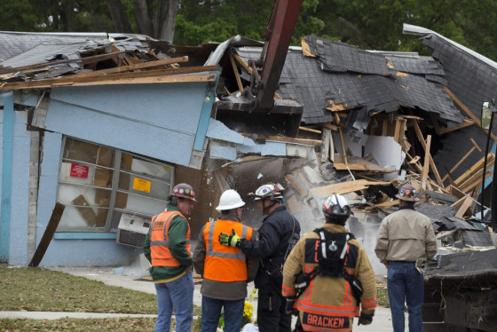 Demolition crews and Hillsborough County Fire Department watch as the house, where Jeffrey Bush was swallowed by a sinkhole, is demolished in Seffner, Florida March 3, 2013.