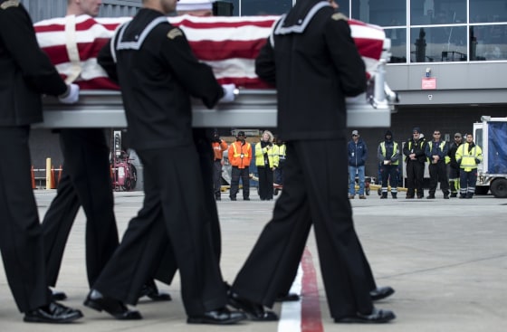 Ground crew and others watch as a US Navy transfer team carries the remains of a United States Civil War (1861-1865) casualty from Delta Flight 1172 to a hearse during a dignified transfer at Dulles International Airport in Sterling, Virginia on Thursday. The remains of two unknown crewmen found inside the sunken iron clad ship, the USS Monitor, were transfered for burial at Arlington National Cemetery after being discovered in 2002 and being sent to Joint POW/MIA Accounting Command in Hawaii for possible genetic identification.