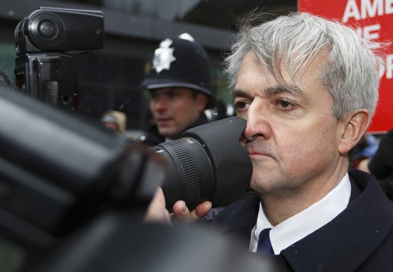 Former British energy minister Chris Huhne comes into contact with a photographer's lens as he arrives at Southwark Crown Court in London on Monday.
