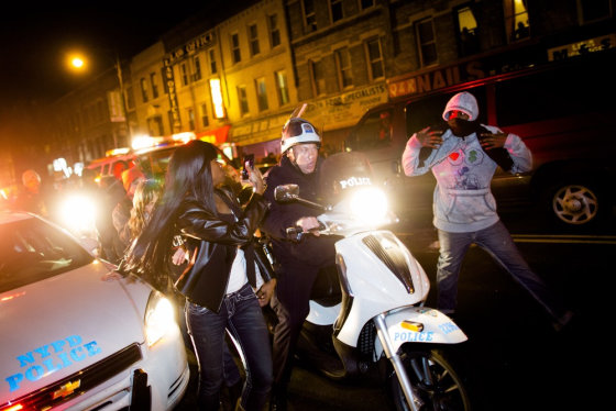 Demonstrators march through the streets alongside police officers during a march following a vigil held for Kimani Gray on March 13, 2013.