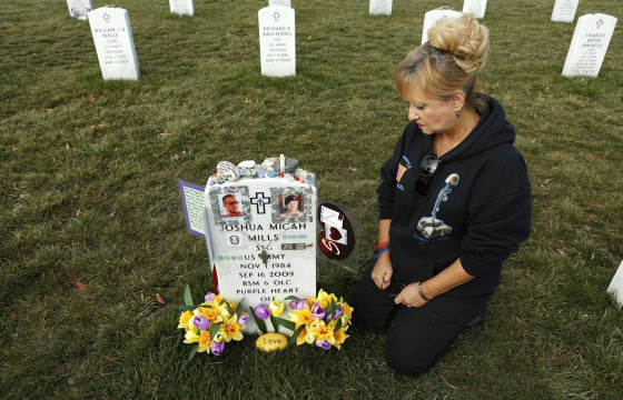 Celeste Mills of El Paso, Texas, kneels beside the grave of her youngest son, Joshua Mills, who was killed in Afghanistan, at Arlington National Cemetery in Virginia, March 13.