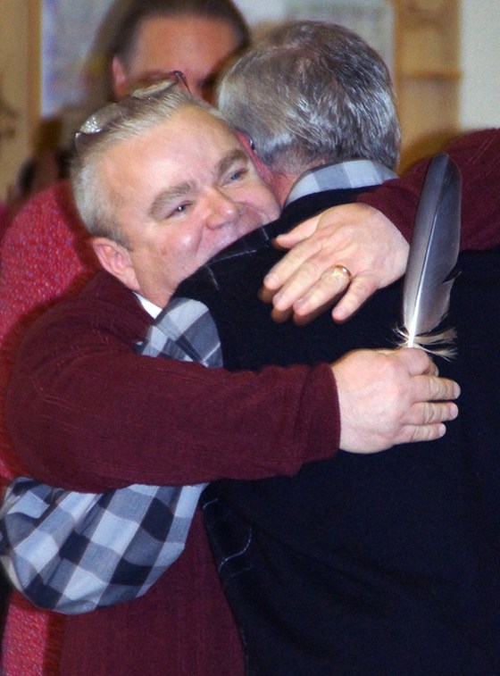Tim LaCroix holds a feather while hugging Gene Barfield after their marriage ceremony on Friday. Both are part of the Little Traverse Bay Bands of Odawa Indians.