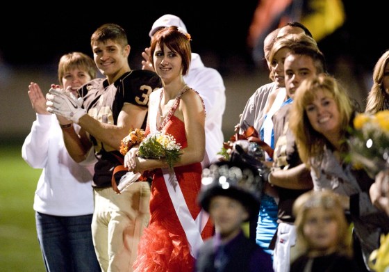 Whitney Kropp, third from left, waits for the ceremony to begin at Ogemaw Heights High School's homecoming football game on Friday.
