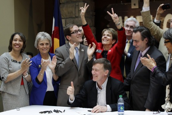 Colorado Gov. John Hickenlooper gives a thumbs up as he celebrates with members of the legislature after he signs the Civil Unions Act into law at the Colorado History Museum in Denver, Colo., on Thursday, March 21, 2013.