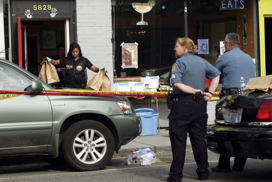 Crime scene investigators remove evidence the scene of a May shooting in Seattle that left six people dead, including the gunman. The Seattle City Council is poised to fund original research into the causes and effects of gun violence.