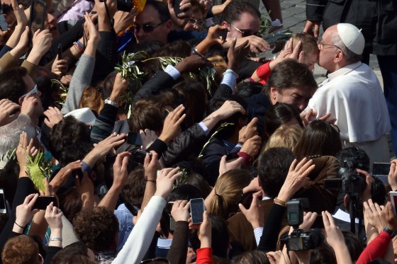 Pope Francis kisses a child after a Mass at the Vatican's St. Peter's Square as part of the Palm Sunday celebration on March 24.