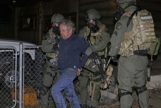 Deputies take Mike McBee into custody in Tacoma, Wash. Tuesday, after he allegedly walked down the street firing guns at houses and then barricaded himself in his home. This photo was provided by the Pierce County Sheriff's Dept.