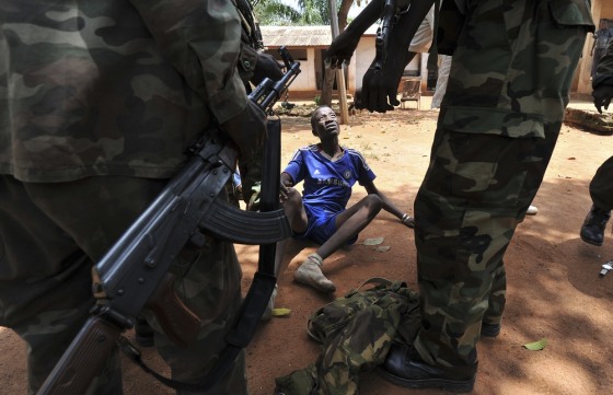 Rebels of the Seleka coalition arrest a man, who was wearing military fatigues and claiming to belong to the Seleka movement, suspected of looting a house in Bangui, Central African Republic, on March 26, 2013.