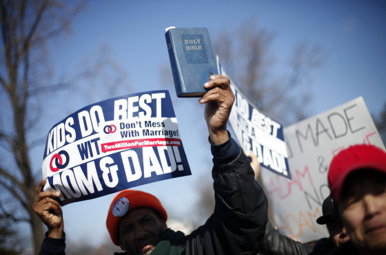 A demonstrator holds a Bible while marching outside the Supreme Court in Washington, on March 26, as the court heard arguments on California's voter approved ban on same-sex marriage, Proposition 8.