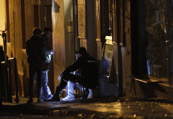 Police officers search for evidence near the home of a prominent Greek ship owner after a makeshift bomb exploded in central Athens on Wednesday.