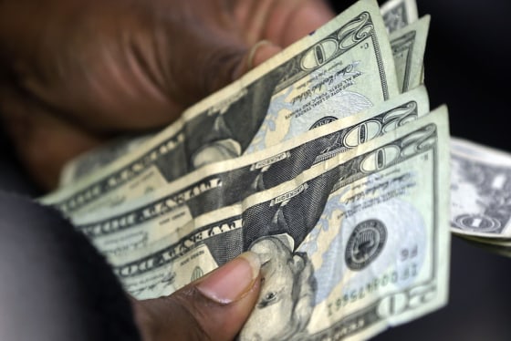 In this Monday, Feb. 25, 2013 photo, a customer counts her change after a purchase at Lodge's store in Albany N.Y. U.S. consumers earned more and spen...