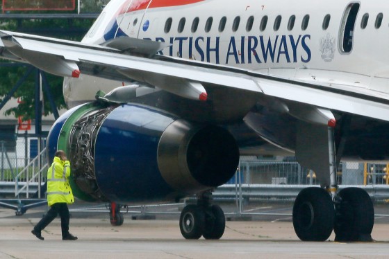 A worker walks past a British Airways passenger jet after it was towed off the runway following an emergency landing at Heathrow Airport west of London on May 24, 2013.