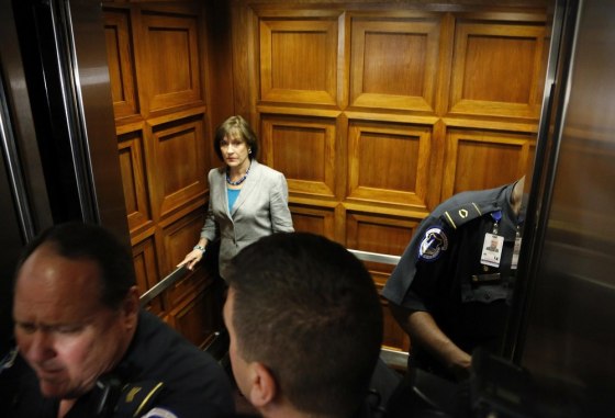 Lois Lerner, director of Exempt Organizations for the IRS, is surrounded by Capitol police as she boards an elevator after being excused from a House Oversight and Government Reform Committee hearing in Washington on Wednesday.