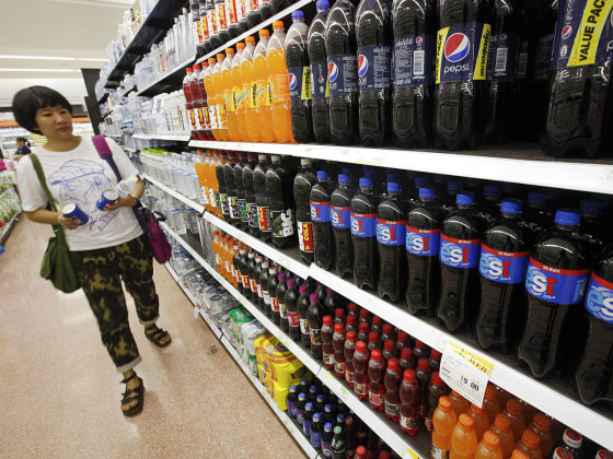 A customer walks past a shelf of soft drinks in Bangkok. A new study links sugar-sweetened sodas with endometrial cancer.