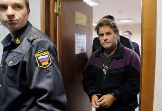A police officer guards Peter Willcox, the U.S. captain of the Greenpeace ship