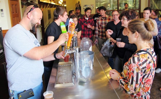 In this Oct. 3, 2013 photo, Mark Paprocki, left, and Dylan Maz pour beer during a tour at Lakefront Brewery in Milwaukee. The federal government shutd...