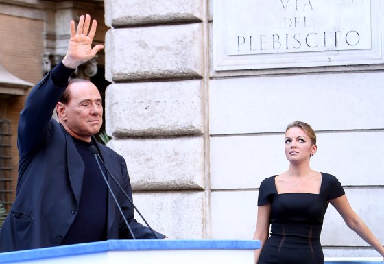 Former Prime Minister Silvio Berlusconi, flanked by his new girlfriend Francesca Pascale, waves to his supporters during a Pro-Berlusconi rally outside his Rome residence, Palazzo Grazioli at Via del Plebiscito, on August 4, 2013.