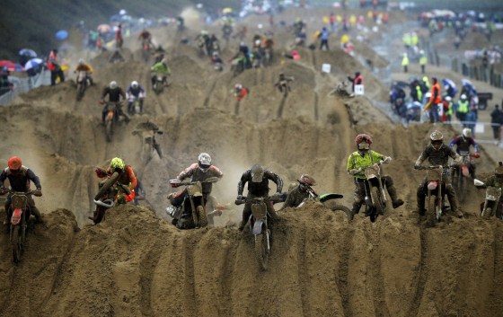 Riders reach the crest of a dune during the opening lap of the main race.