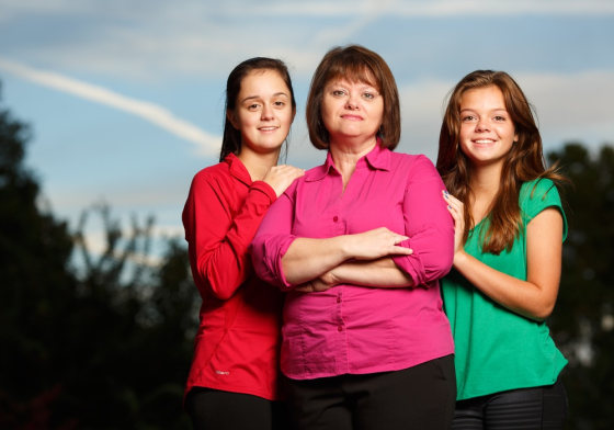 Cheyenne Phillips, 17, Angela Phillips, 44, and Cassidy Phillips, 14, stand outside their home in Knoxville, TN. Phillips is a divorced mom that shares joint custody of three kids with their dad. She was on food stamps from from July 2012 to February 2013, and will be applying for the benefit again on Monday because her temp job is ended on Friday.Photo by Steven Bridges