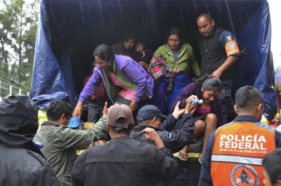 Police help people get off a truck on their way to a makeshift shelter in the city of Chilpancingo on Monday.