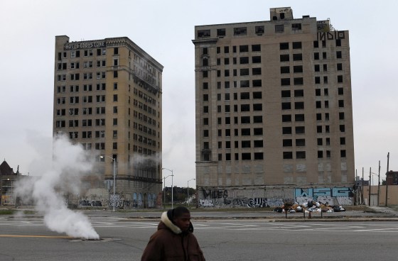 A man walks past two abandoned buildings in Detroit on Friday, Oct. 25, the third day of a trial to determine whether the city is eligible for bankruptcy.