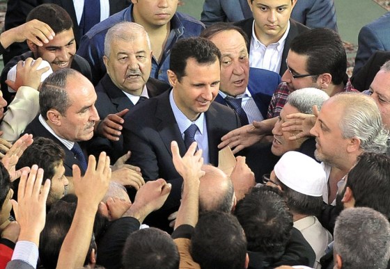 Syrian President Bashar al-Assad being greeted by supporters following Eid al-Adha prayers at the Sayeda Hassiba mosque in Damascus' northwestern Dumar neighborhood on October 15, 2013.