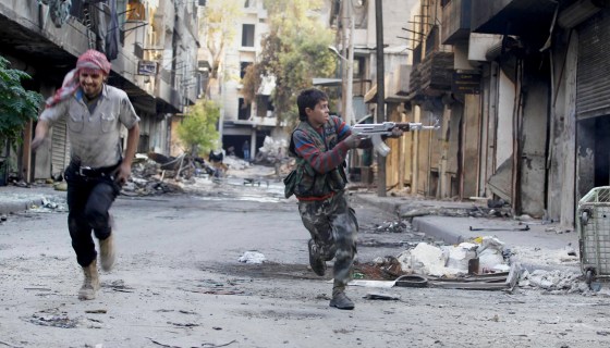 Mohammad, a 13 year-old fighter from the Free Syrian Army, aims his weapon as he runs from snipers loyal to the Syrian regime in Aleppo's Bustan al-Basha district Oct. 29, 2013. Mohammad joined the Free Syrian Army after his father died during clashes with the Syrian regime. The gun he is using was his father's.