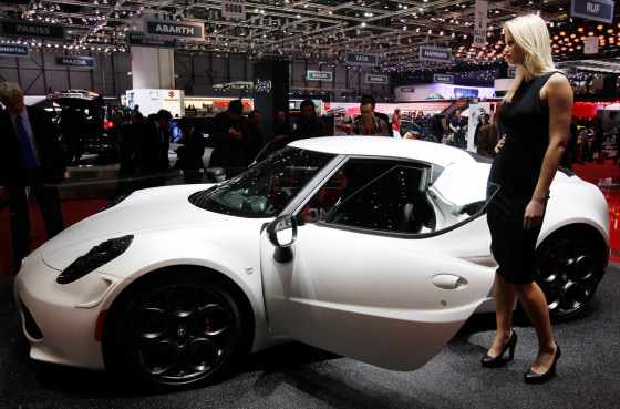 A model stands next to the Alfa Romeo 4C displayed on the company's booth during the first media day of the Geneva Auto Show at the Palexpo in Geneva ...