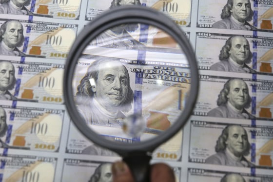 A sheet of uncut $100 bills is inspected during the printing process at the Bureau of Engraving and Printing Western Currency Facility in Fort Worth, ...