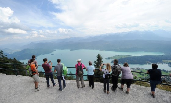 Hikers standing on the Herzogstand mountain look toward Lake Walchensee in the Bavarian foothills of the Alps. The area has become popular with treasures hunters.
