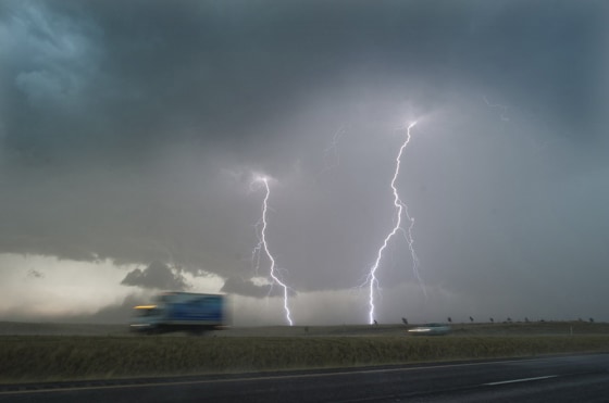 Dual bolts of lightning strike along Highway 12 just north of Walla Walla, Wash., at the height of an evening storm.