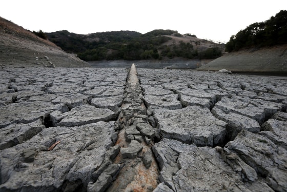 A pipe emerges from dried and cracked earth that used to be the bottom of the Almaden Reservoir Tuesday in San Jose, Calif.