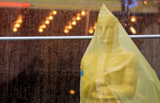 An Oscar statue covered in plastic stands on the red carpet Friday as preparations are made during rainy weather for the 86th Academy Awards in Los An...