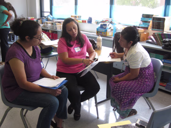 Parent mentor coordinators with the Logan Square program prepare for a group presentation during a summer training session.