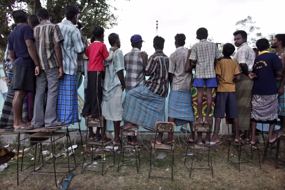 Tamil people chat with their relatives over the fence of a temporary refugee camp in Vavuniya, northern Sri Lanka